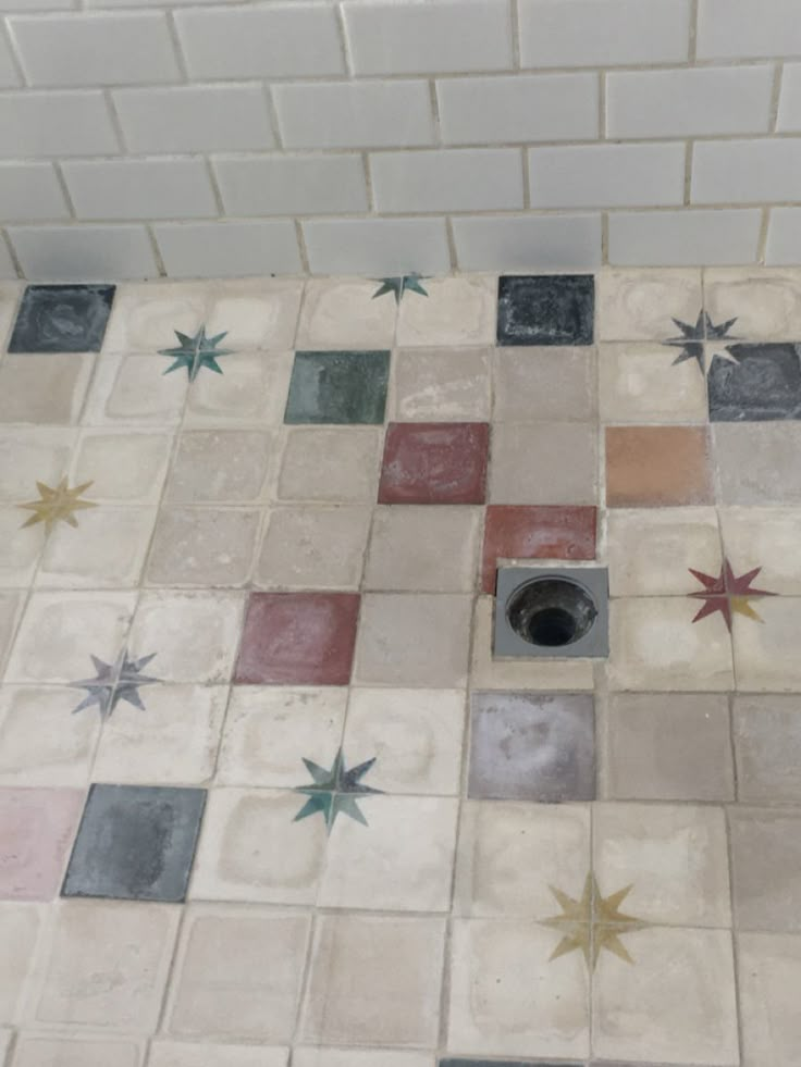 a tiled floor with stars on it and a hole in the middle that is surrounded by tiles