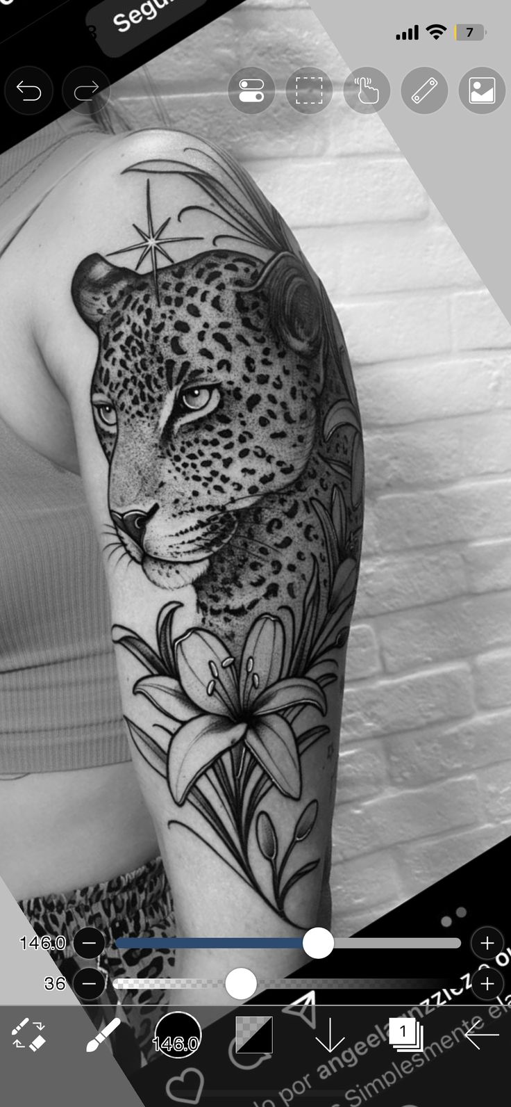 a black and white photo of a woman's arm with a leopard tattoo on it