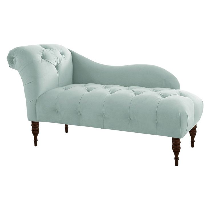 a light blue chaise lounger with wooden legs and tufted upholster