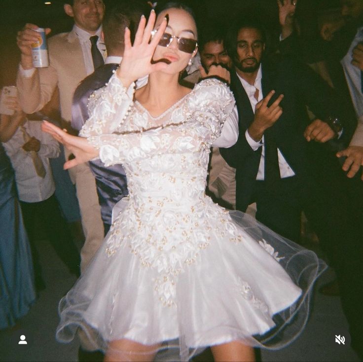 a woman in a white dress dancing at a party