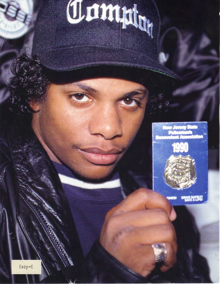 a young man wearing a hat and holding up a medal