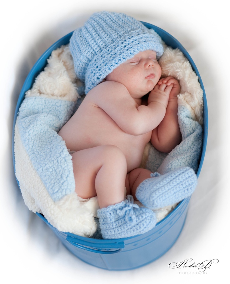 a baby is sleeping in a blue bucket