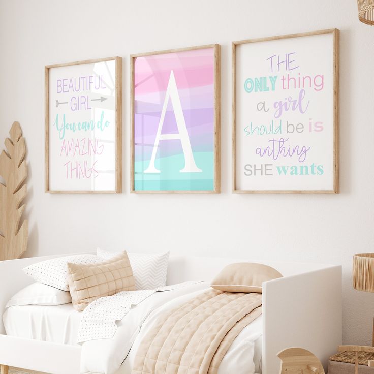 three framed art prints hang on the wall above a small bed in a white bedroom