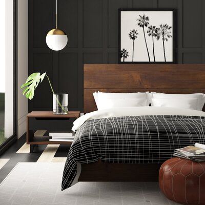 a bedroom with black walls and white bedding