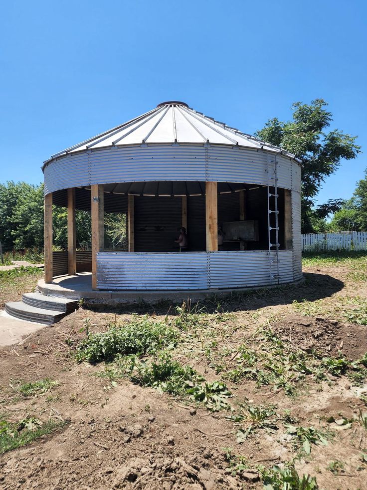 an old round building sitting on top of a dirt field