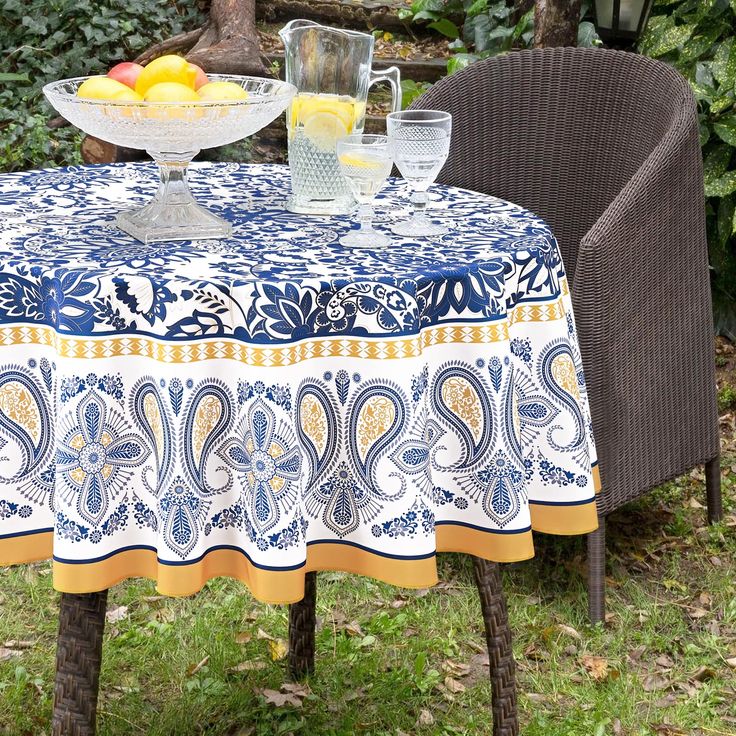 an outdoor table and chairs with a bowl of fruit on it