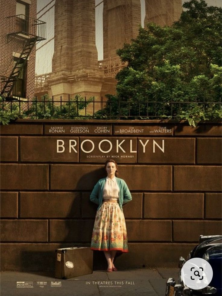 a woman standing in front of a brick wall with the words brooklyn written on it