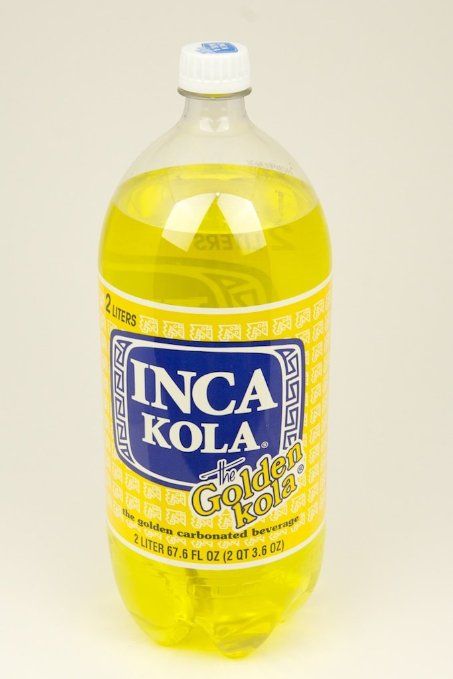 a bottle of soda that is sitting on a white surface with the caption inca kola