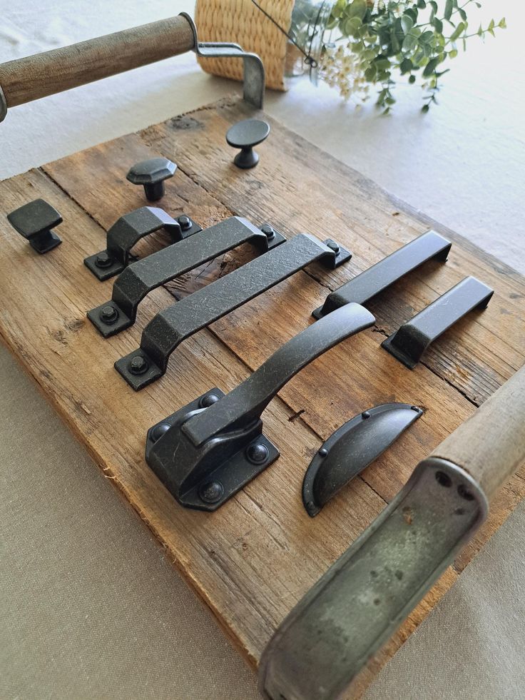 an assortment of metal handles on a wooden board