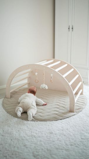 a baby laying on top of a bed next to a white wardrobe and closets