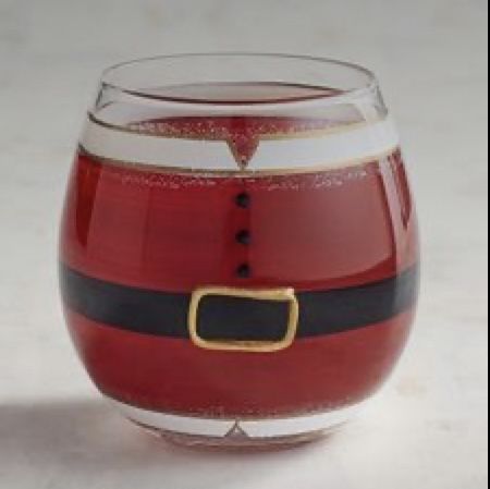 a red glass filled with liquid and topped with a santa clause belt around the bottom