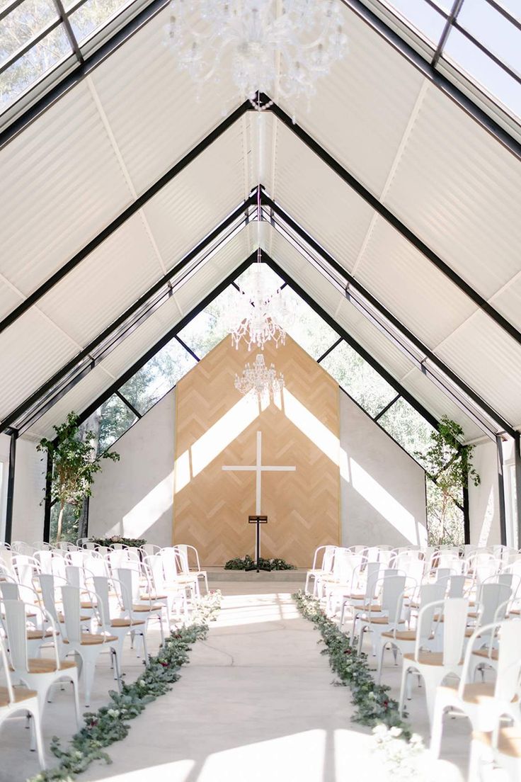 the inside of a church with rows of white chairs