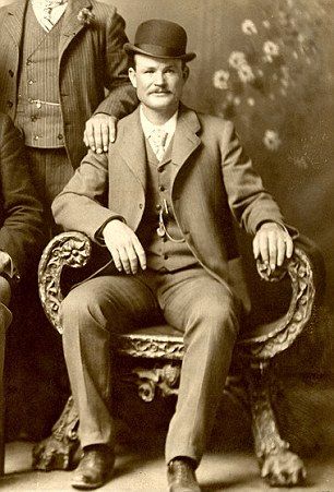 an old black and white photo of two men sitting next to each other on a chair