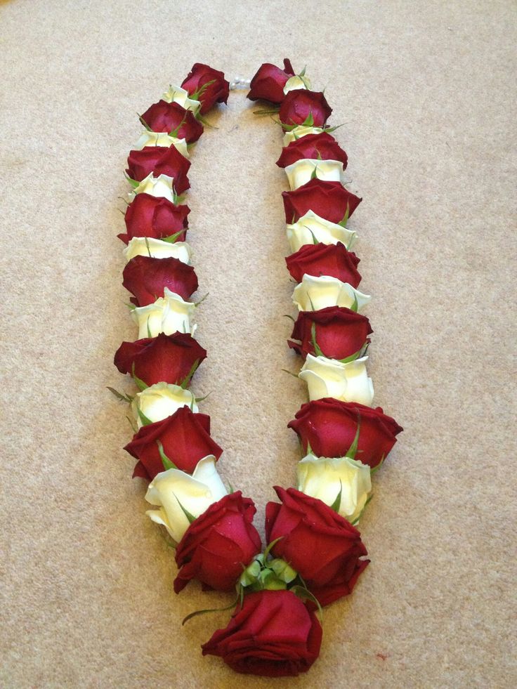 a long line of red and white roses arranged in the shape of the letter u