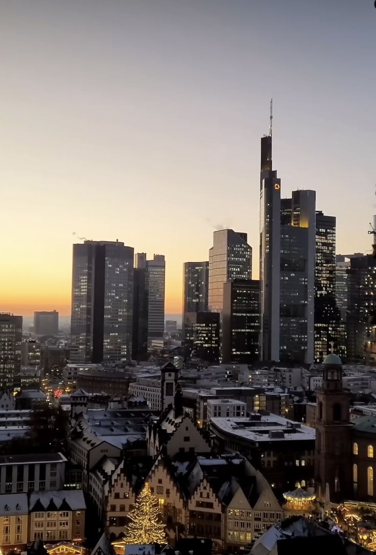 the city skyline is lit up at night with buildings in the foreground and skyscrapers in the background