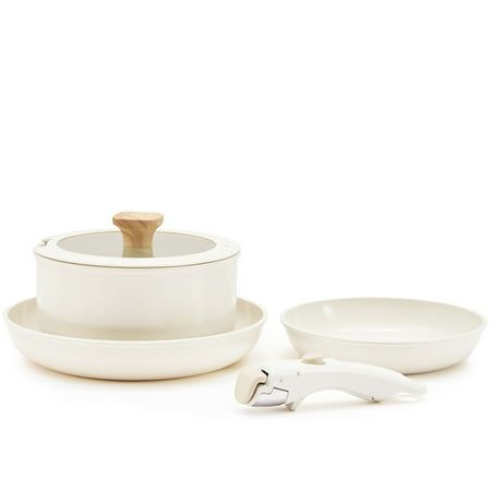 a set of white dishes with wooden spoons on the side and one bowl in front