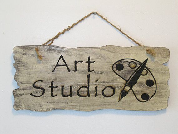 a sign that says art studio hanging on a wall