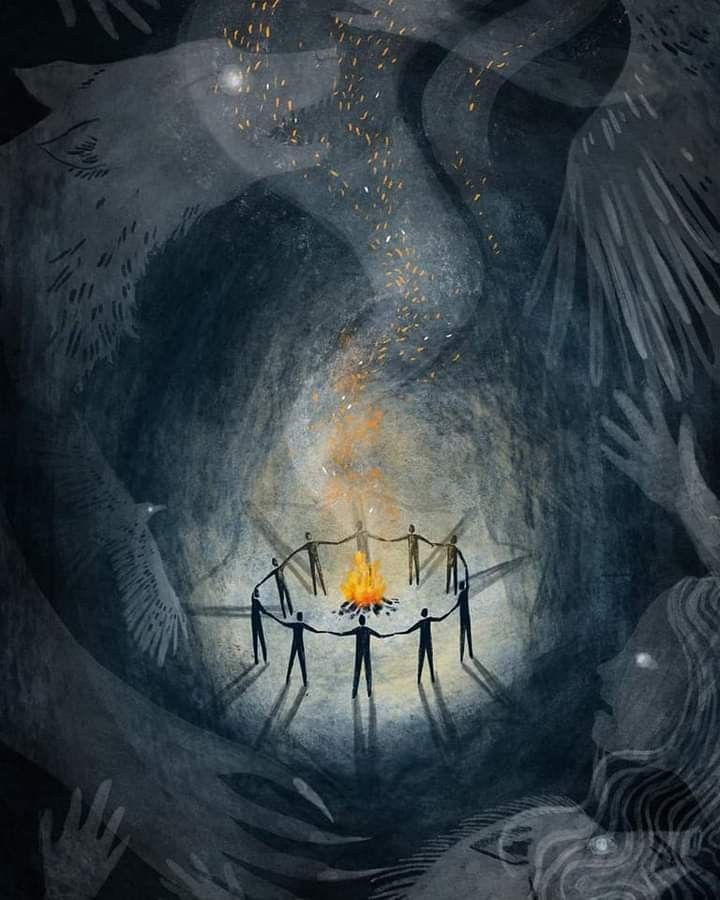 people holding hands around a fire in the middle of a dark cave with flames coming from it