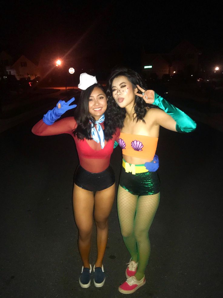 two women dressed in costumes posing for the camera