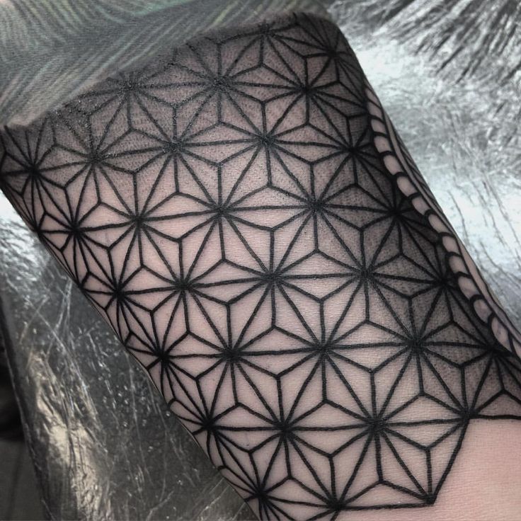 a black and white photo of a flower of life tattoo