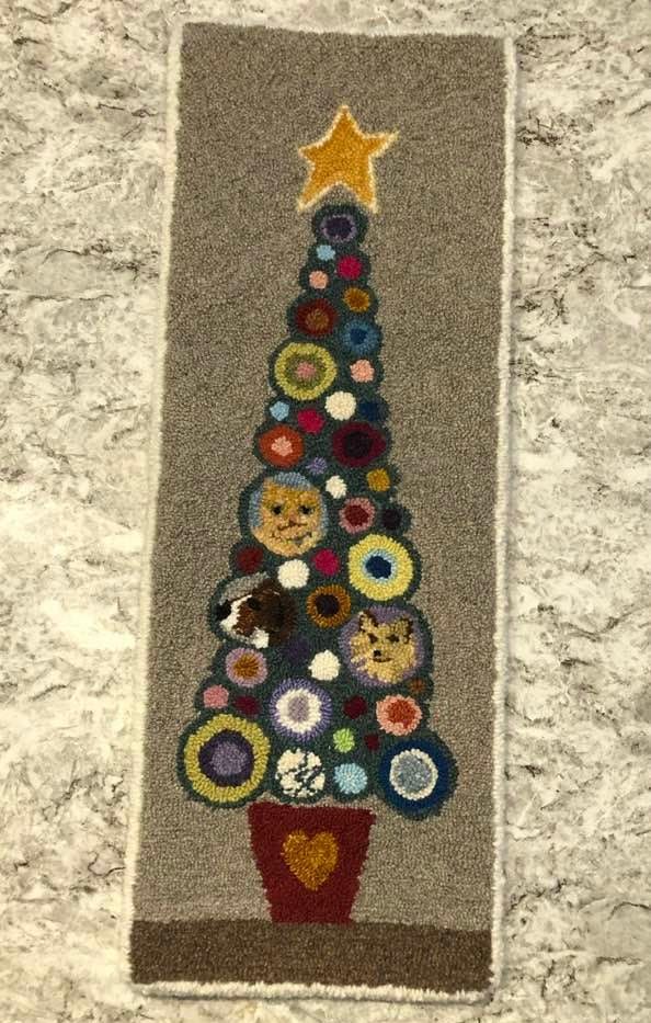 a christmas tree rug hanging on the wall