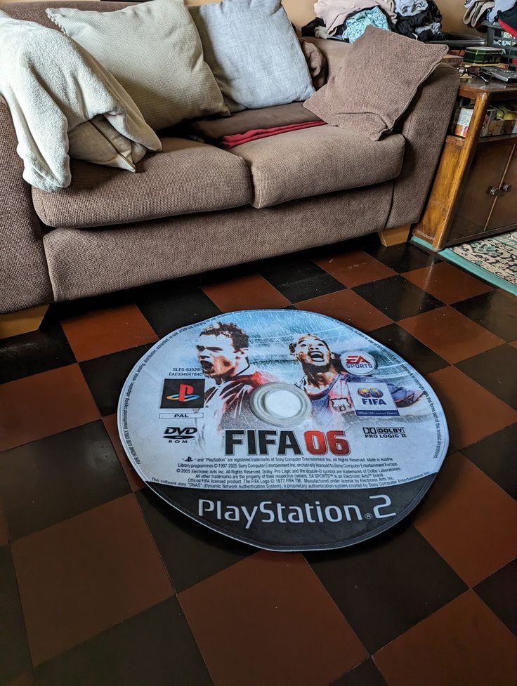 a video game sitting on top of a black and white checkered floor next to a couch