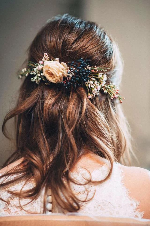 the back of a woman's head with flowers in her hair, wearing a wedding dress