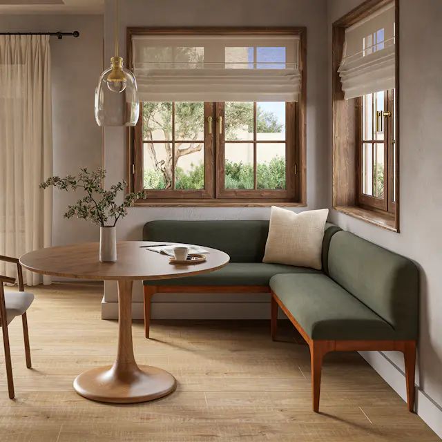 a living room with a couch, table and chairs next to a window in the corner