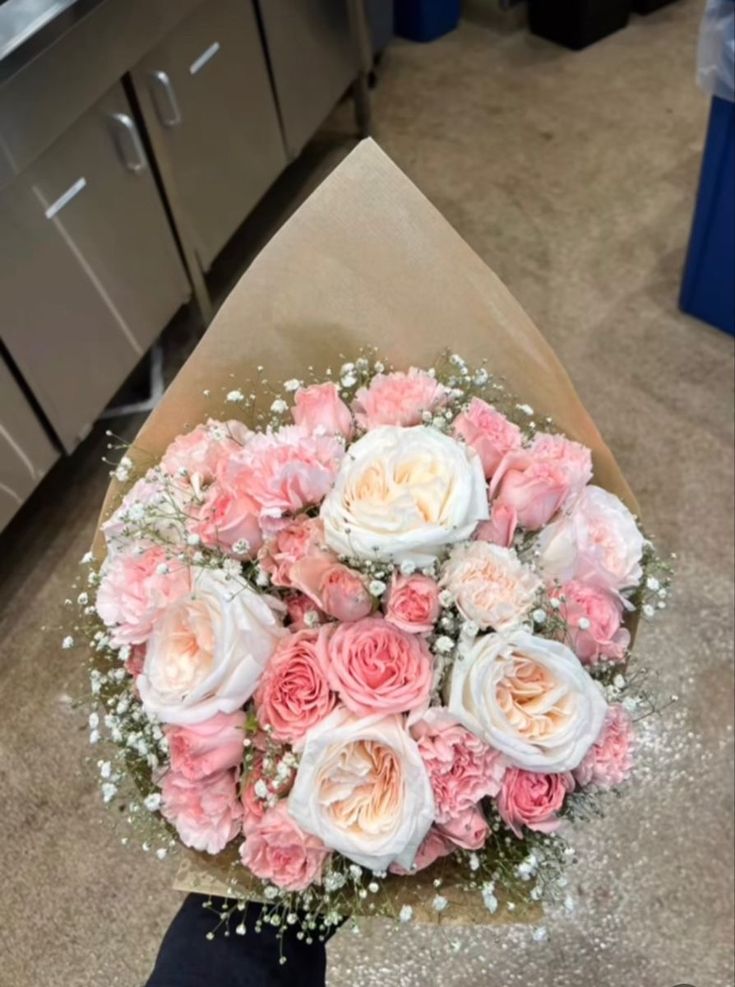 a bouquet of pink and white flowers sitting on top of a table