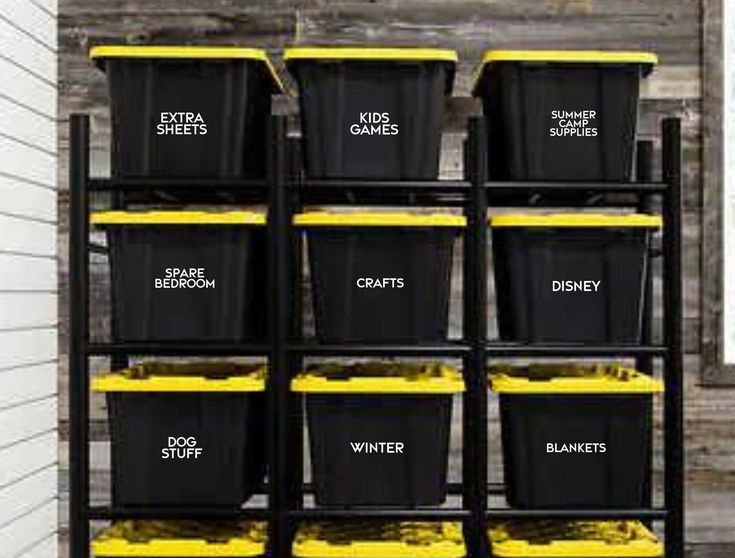 a bunch of black and yellow bins are on a shelving unit with labels