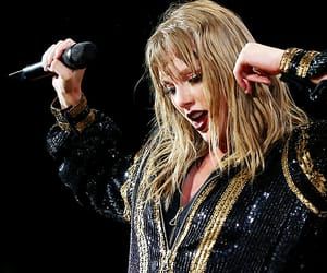 a woman with long blonde hair holding a microphone in her hand and singing into the microphone