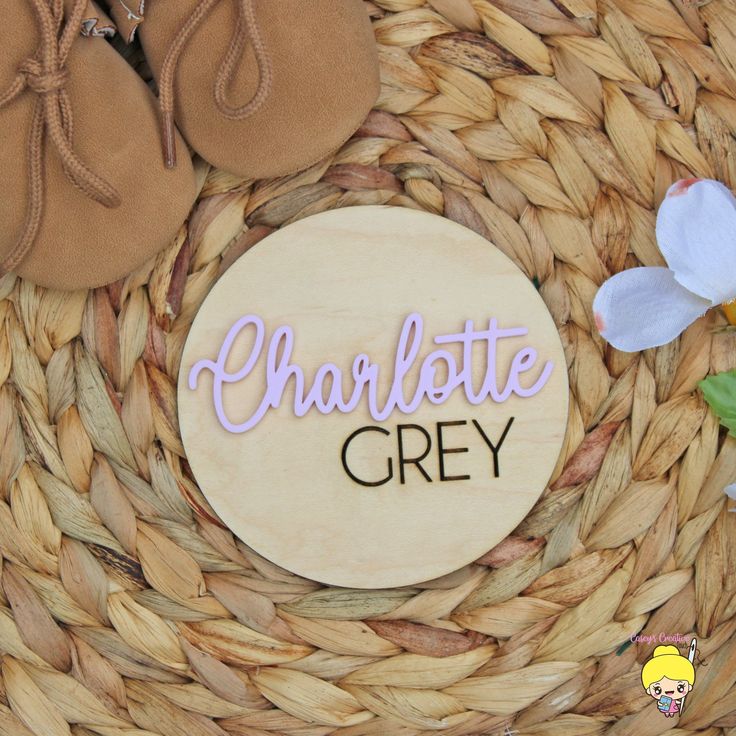 there is a sign that says charlotte grey next to some shoes and flowers on a basket