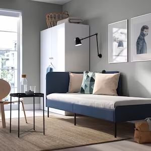 a living room filled with furniture and pictures hanging on the wall next to a window