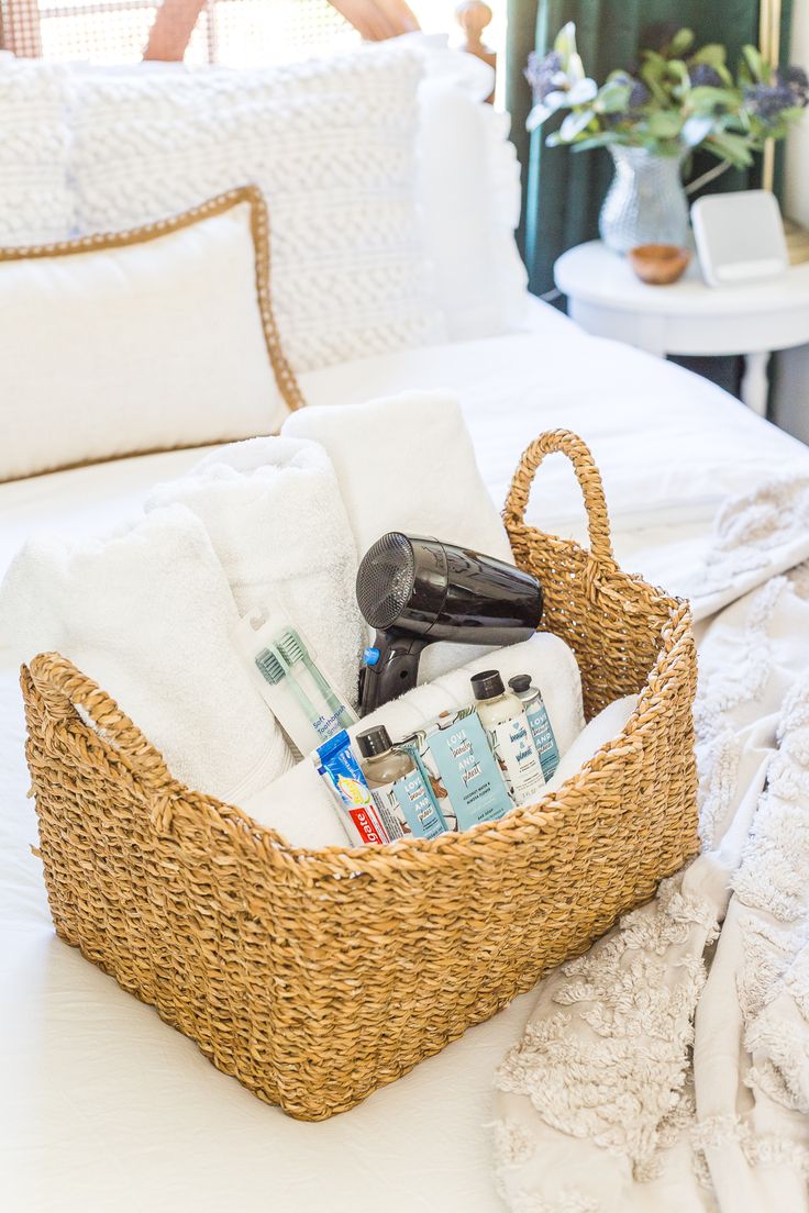 a wicker basket filled with personal care items on top of a white bedspread