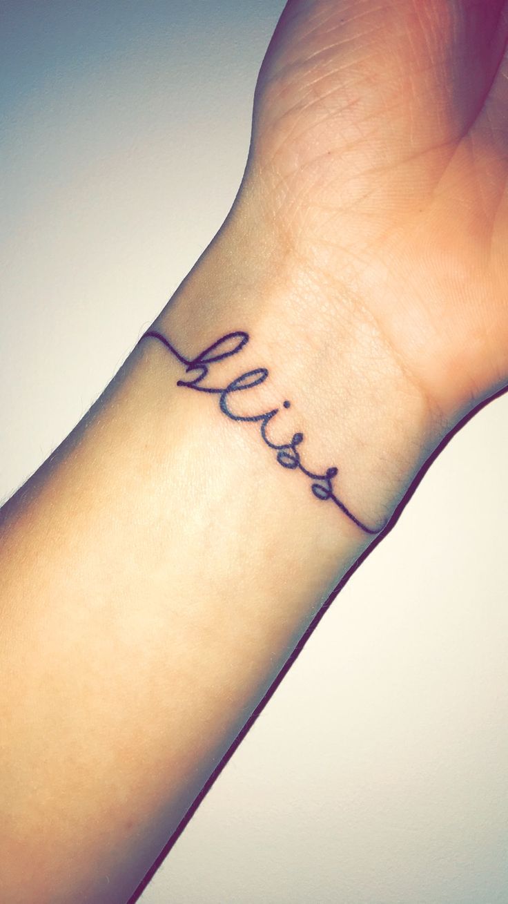 a small wrist tattoo with the word love on it