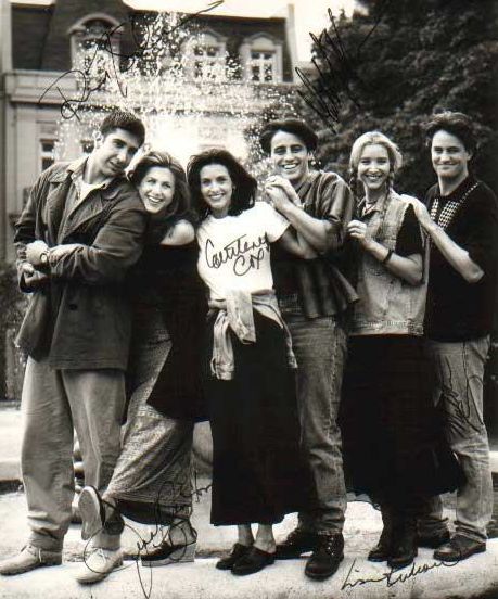 a group of people standing next to each other in front of a building with trees