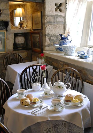 there is a table set with tea cups and saucers on it in the dining room