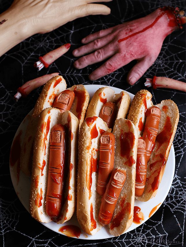 several hot dogs are on a plate with ketchup