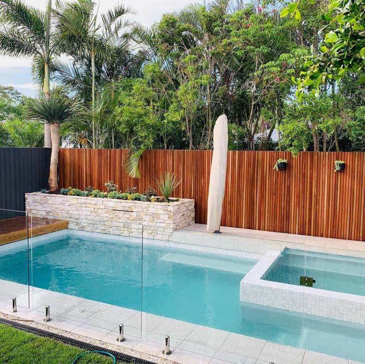 a backyard with a swimming pool and wooden fence