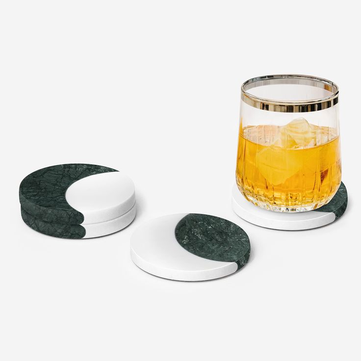 two coasters and a glass with ice on them