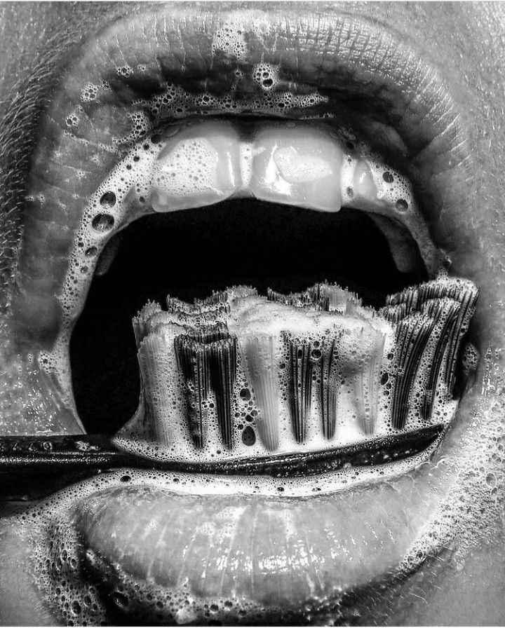 a black and white photo of an open mouth with water droplets on it's teeth