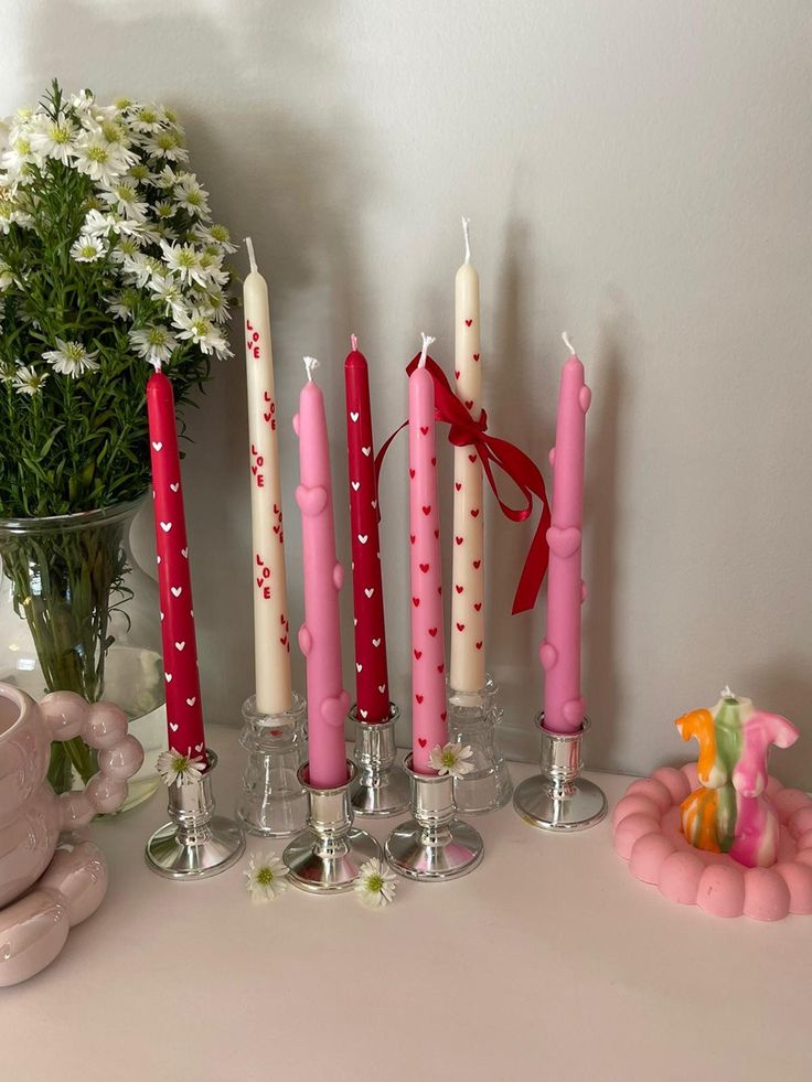 pink candles are lined up on a table