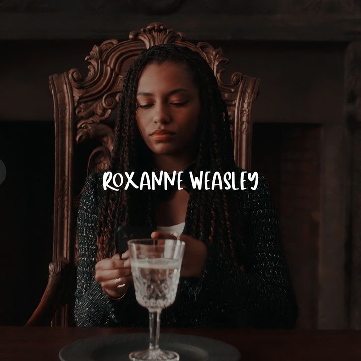 a woman sitting at a table with a glass in front of her and the words roxanna weasley on it