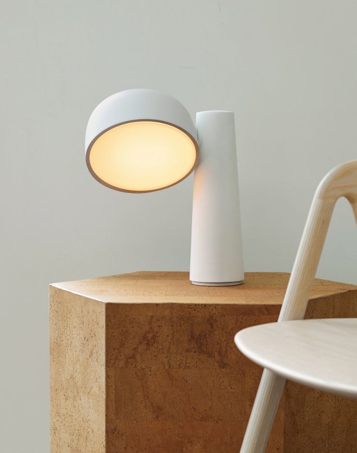 a white lamp sitting on top of a wooden table