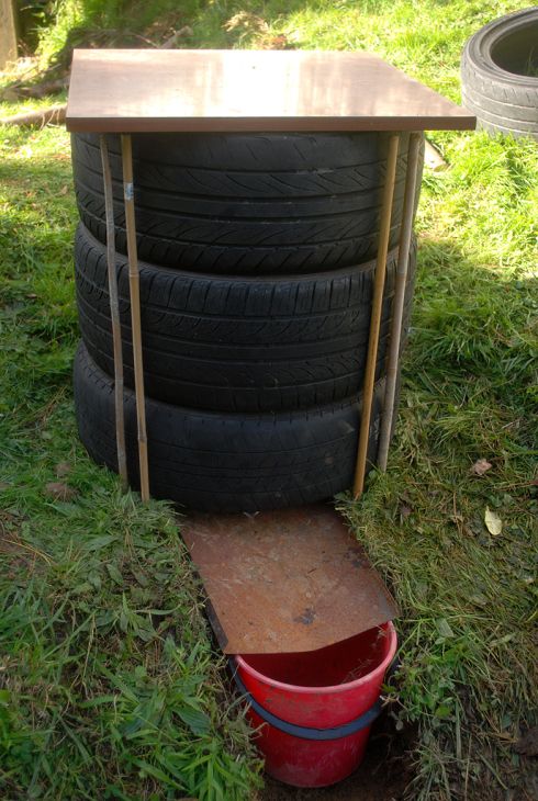 two tires stacked on top of each other in front of a table and some buckets