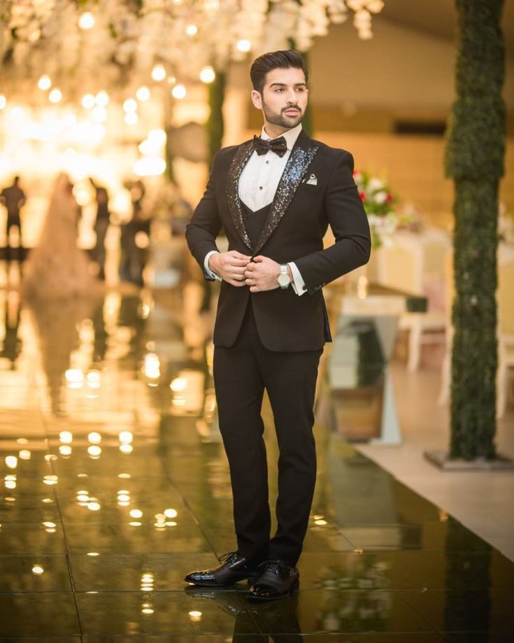 a man in a tuxedo is posing for the camera