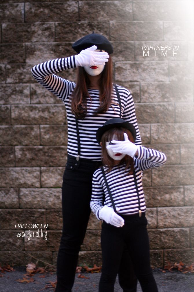 two women dressed in black and white posing for the camera with their hands on their faces