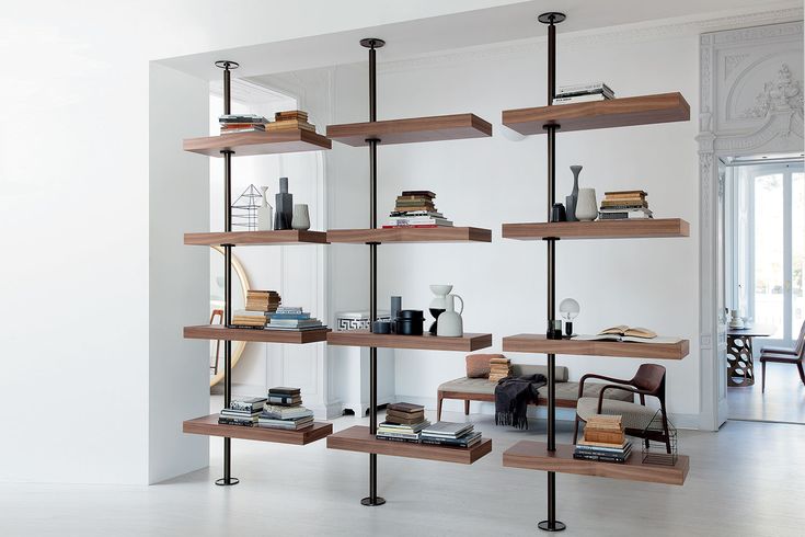 a bookshelf filled with lots of books on top of wooden shelves in a room