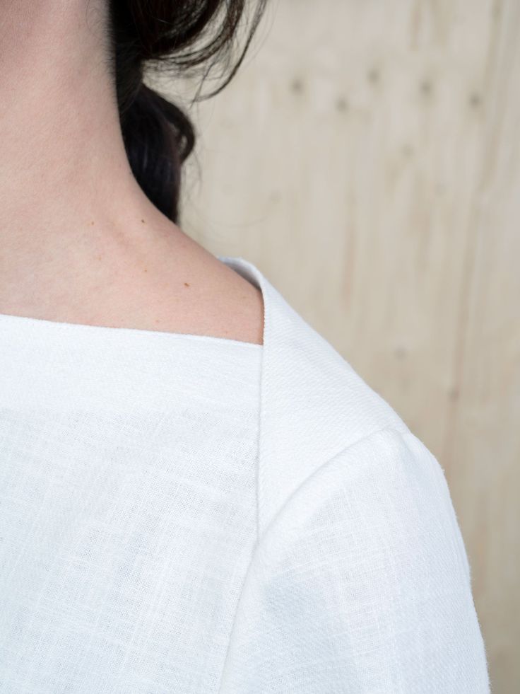 a close up of a woman's neck wearing a white shirt