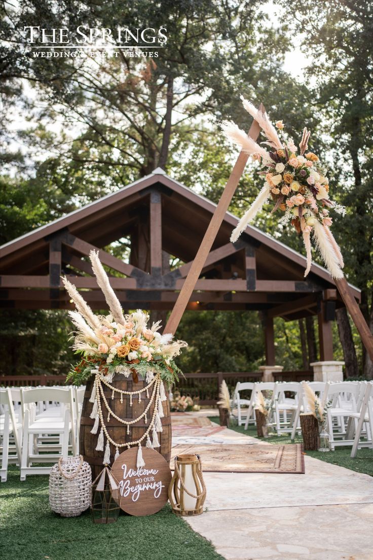 an outdoor ceremony setup with white chairs and flowers